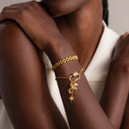 Woman wearing gold bracelets, including a star charm bracelet and an opal piece secured with the Opal Carabiner Clasp, crossing her arms.