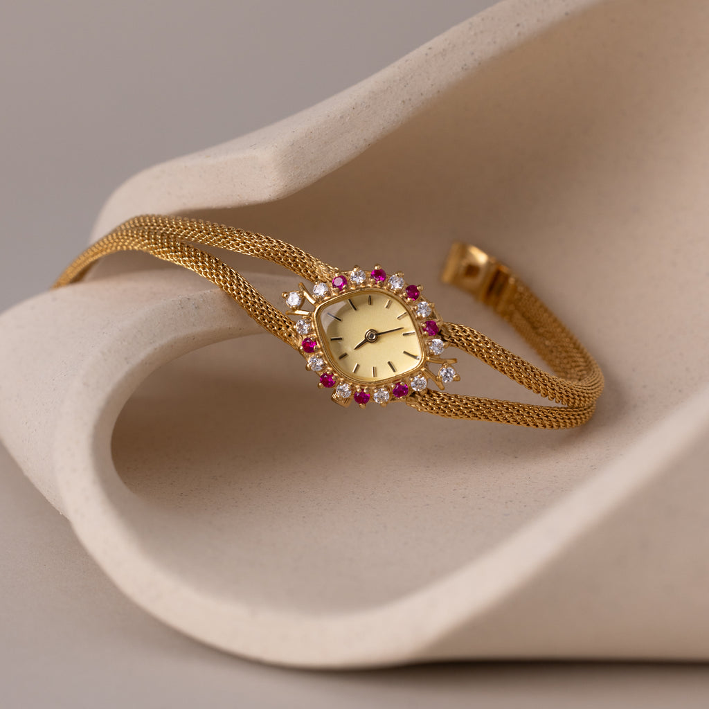 Close up of our Duo Chain Ruby Timepiece watch laid onto a ceramic dish