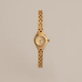 Our Petite Round Timepiece watch on a beige background