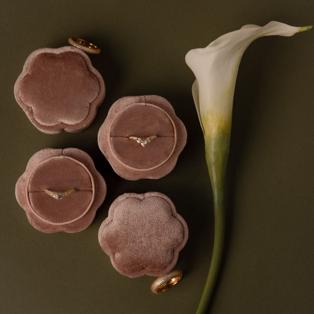 The Pink Flower Velvet Ring Box, ideal for proposals, beautifully displays diamond rings alongside a white calla lily on an olive green background.