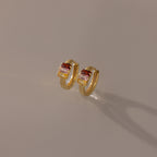 Multiple Baguette Birthstone Huggies in 18K Gold shown on a neutral background, perfect for adding a pop of colorful elegance to any outfit.