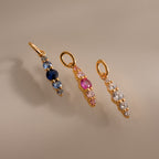 Three Ombre Lace Birthstone Charms—gold pendants with blue, pink, and clear gemstones—arranged vertically on a neutral background.