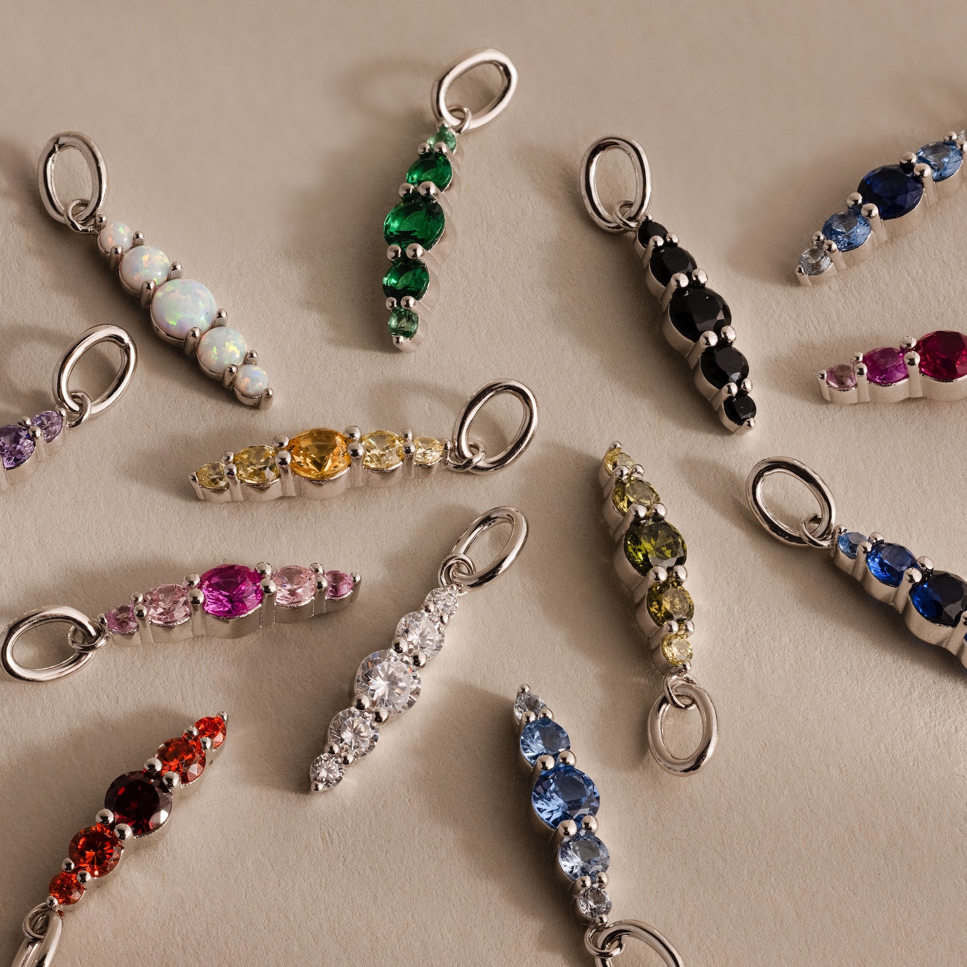 The Ombre Lace Amethyst Charm, featuring a silver loop, shines among assorted gemstone charms—perfect for a unique personalized accessory or thoughtful birth month gift.