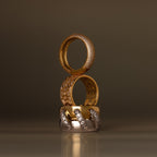 Three elegant rings, featuring the Mosaic Diamond Baguette Ring with baguette-cut stones, are stacked vertically in gold and silver tones with diamond accents against a neutral backdrop.
