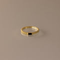 The Dainty Ribbed Onyx Ring features a thin gold band with a subtle ridged design and a small black rectangular onyx detail, shown against a neutral background.