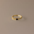 The Dainty Ribbed Onyx Ring features a thin gold band with a subtle ridged design and a small black rectangular onyx detail, shown against a neutral background.