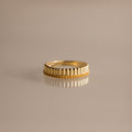 The Ribbed Topaz Stack Ring features a sculpted ribbed texture with small beads, ideal for a chic ring stack. Shown on a reflective, neutral surface.