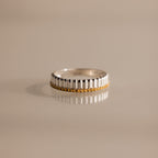 The Ribbed Topaz Stack Ring features a sculpted ribbed texture and a row of small yellow topaz stones set around the band, displayed on a shiny surface.