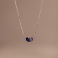 The Toi et Moi Teardrop Heart Necklace in Sterling Silver features two pear-cut stones—one blue, one purple—set on a plain background; a timeless keepsake ideal for any occasion.