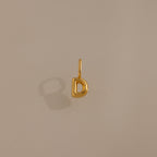Bubble Letter Charm in 18K Gold D pendant displayed on a neutral beige background with a soft left shadow—ideal personalized jewelry or a charming addition for bracelet enthusiasts.