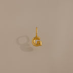 The Bubble Letter Charm in 18K Gold, shaped as the letter G, offers a stylish personalized jewelry option and is showcased on a simple beige background.