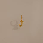 The Bubble Letter Charm in 18K Gold, shaped like the letter J and photographed on a plain beige background, makes a perfect personalized jewelry piece or a charming addition to your bracelet.