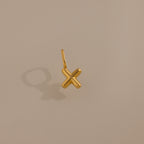 The Bubble Letter Charm in 18K Gold rests on a beige background, casting a shadow left—ideal for personalized jewelry or as a unique addition to any bracelet collection.