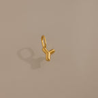 The Bubble Letter Charm in 18K Gold, shaped like the letter Y, is displayed on a beige background with a soft shadow—ideal as a personalized jewelry charm for bracelets.
