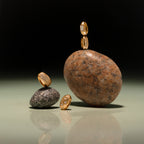 The Baguette Diamond Charm glistens elegantly atop and beside smooth stones, creating a striking display against a minimalist gradient background.