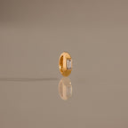 The Baguette Diamond Charm in 18K Gold features a rectangular clear gemstone set upright, reflecting light beautifully for an elegant touch to any jewelry collection.