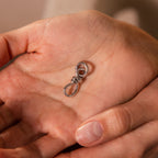 A hand holds the Knot Charm Clasp in Silver, a stylish and durable silver metal clasp perfect for jewelry making and accessories.