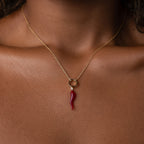 The Chili Pepper Charm in 18K Gold rests elegantly on the neck and collarbone, adding a playful touch to any jewelry collection.