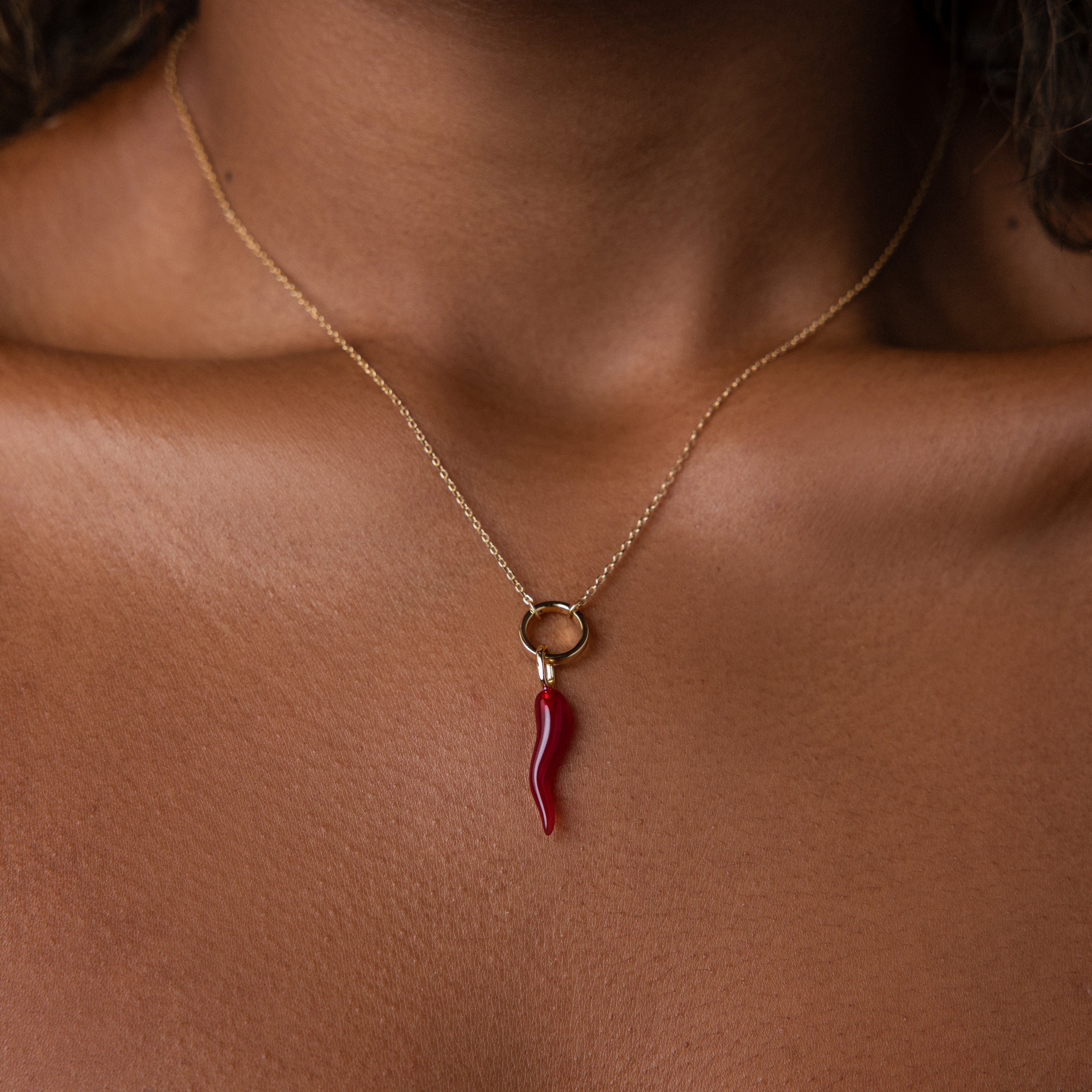The Chili Pepper Charm in 18K Gold rests elegantly on the neck and collarbone, adding a playful touch to any jewelry collection.