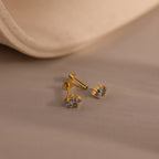 Rhombus Blue Zircon Flatback Studs feature square-cut blue zircon stones for a modern, understated chic look, shown on a soft beige surface with a gently curved background.
