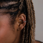 Close-up of a model with a silver cuff earring and braided hair.