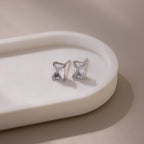 Pair of silver rectangular-cut stud earrings on a beige surface