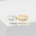 A silver Handwriting Band engraved with "I love you" and a gold custom ring with "miss you right now" rest on a white surface—ideal as heartfelt Christmas gifts.