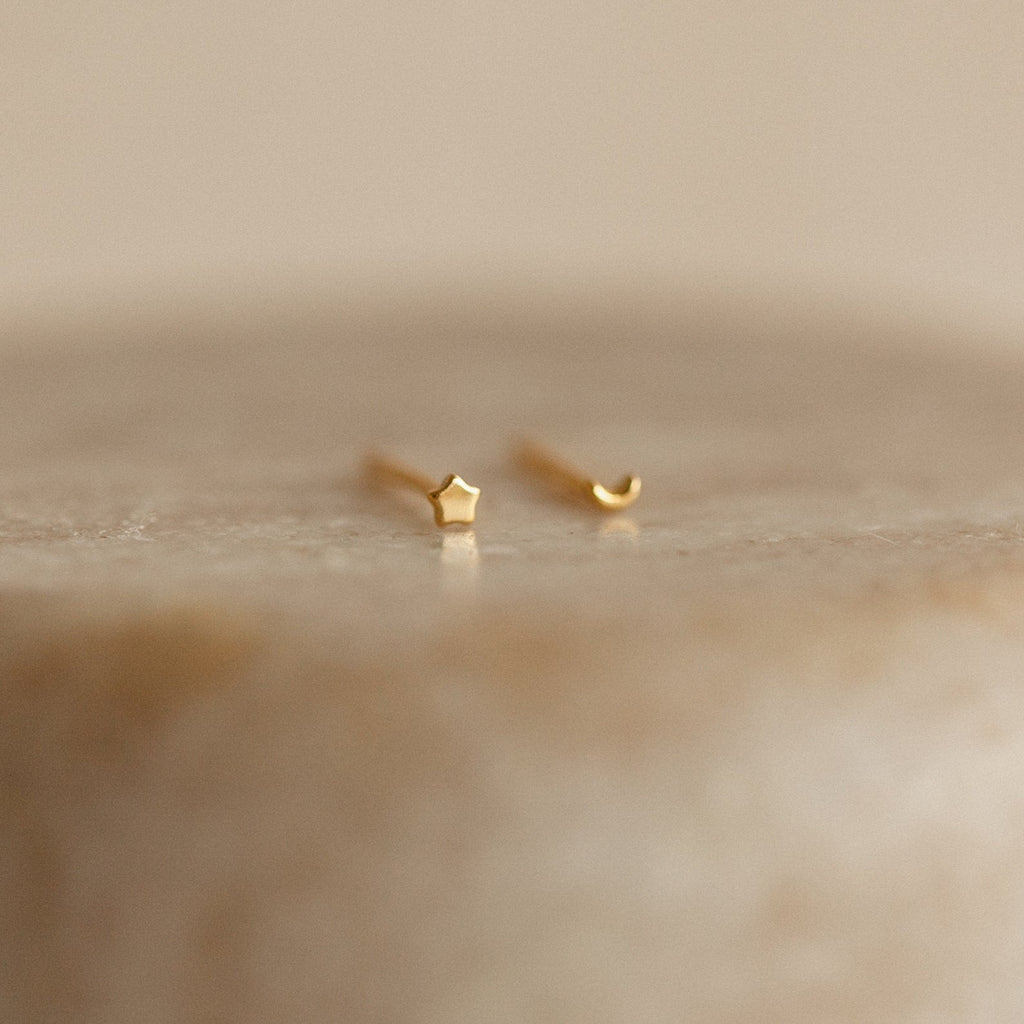 The Tiny Moon & Star Studs in 18K Gold, featuring one star and one crescent moon design, add a celestial touch that's perfect for constellation-themed jewelry lovers.