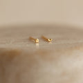 The Tiny Moon & Star Studs in 18K Gold, featuring one star and one crescent moon design, add a celestial touch that's perfect for constellation-themed jewelry lovers.