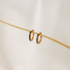 Black Onyx Hoops Bundle: gold hoop earrings with small black onyx stones, displayed on a thin beige stick against a light background.