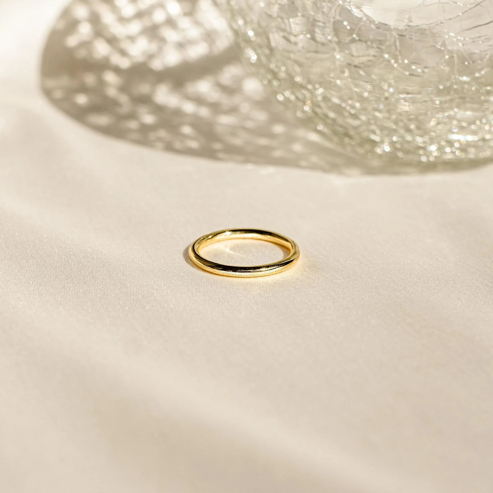 The Agate Diamond Rings Set, inspired by vintage designs, is displayed on soft light fabric next to a textured glass object.