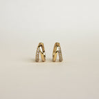 Product display of Amelia Duo Huggies in 18K Gold standing upright on a light background.
