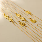 Initial Rectangle Pendant Necklaces are neatly arranged on a light surface, featuring striking sun designs and customizable options for personal initials.