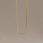 The Men's Snake Chain Necklace hangs against a plain, neutral background, showcasing minimalist elegance and timeless style—an ideal choice for men’s jewelry.