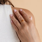 A hand with light pink nails wearing the Citrine Emerald Ring rests on a shoulder—the ideal accent for anyone who loves the warm glow of November’s birthstone.