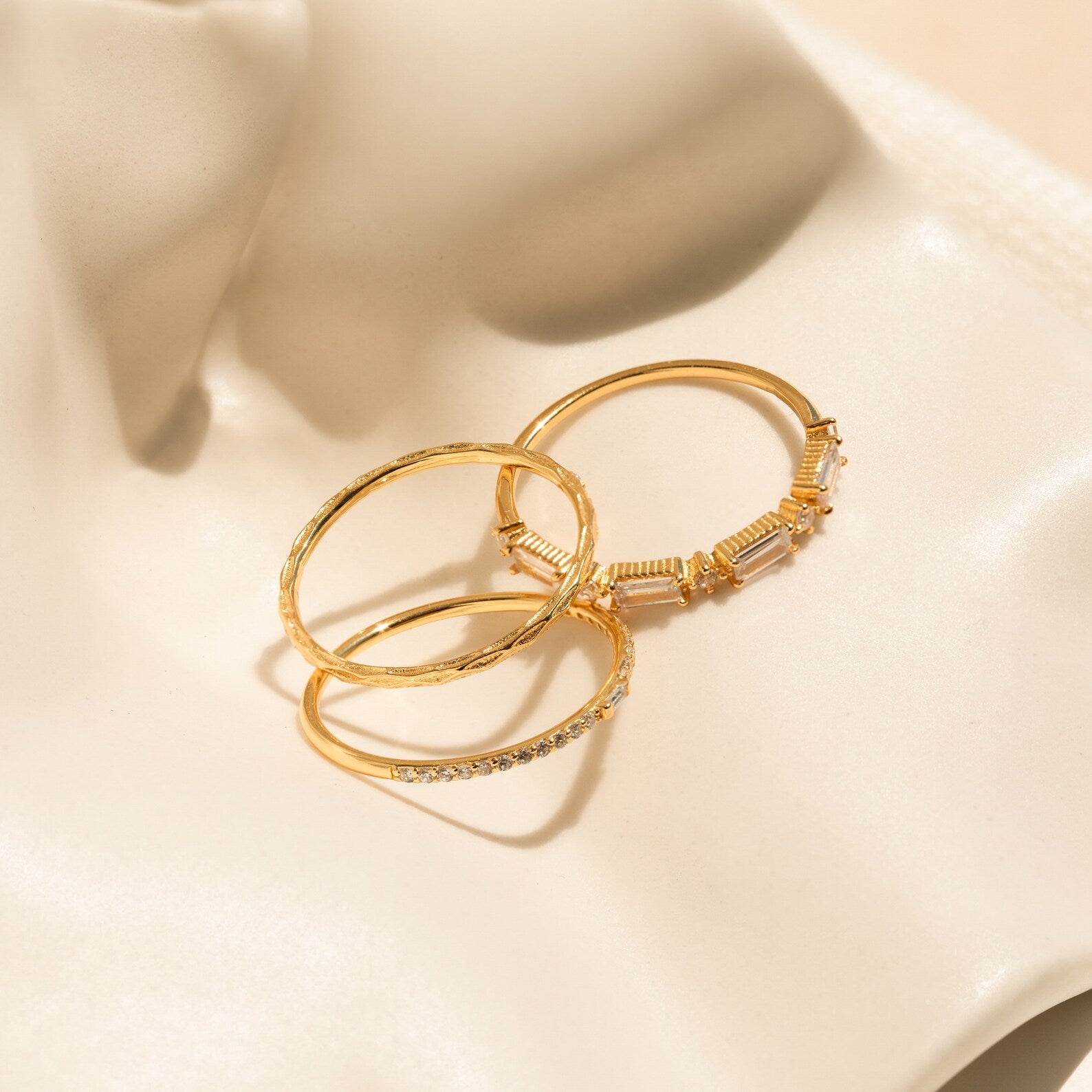 The Diamond Stacking Ring Set in 18K Gold features three unique gold rings displayed on ivory satin—an elegant and thoughtful Christmas gift.