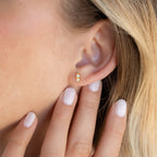 A close-up of a woman's ear wearing Duo Birthstone Studs, elegant earrings that make a perfect and thoughtful bridesmaids gift.
