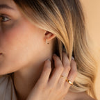 Blonde woman gently touching her hair while wearing Inside Out Diamond Huggies in Sterling Silver.