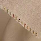 A pair of Amethyst Drop Studs is displayed on a beige textured surface, showcasing vibrant gemstone elegance perfect for gifting or everyday wear.