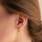 A close-up of a woman's ear with hair pulled back, showcasing the vibrant Green Opal Inlay Hoops.