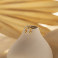 Opal Drop Studs accessorize a smooth white vase, set against a soft beige background.