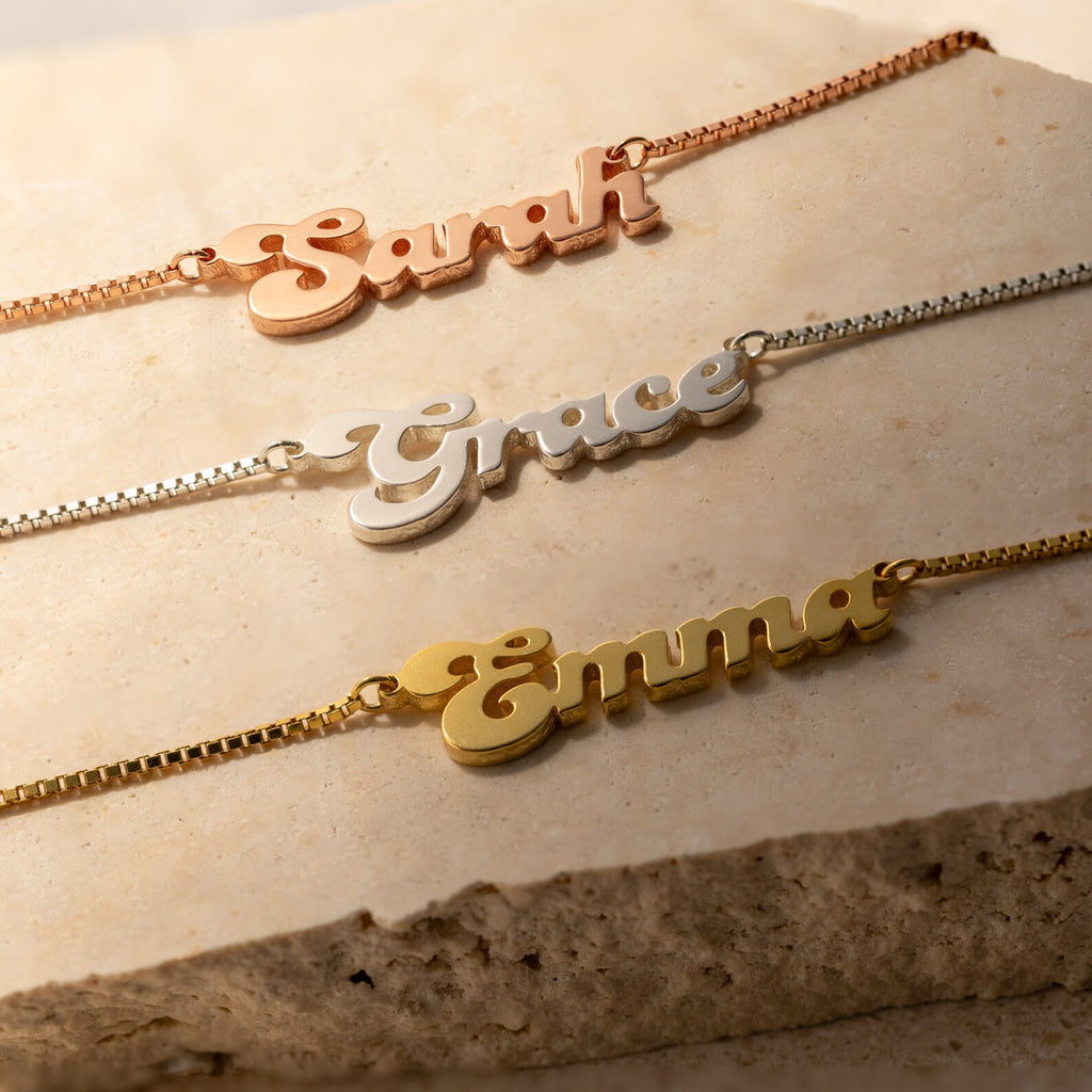 The Groovy Name Necklace in Box Chain is a custom piece available in rose gold, silver, and gold—personalized with names like Sarah, Grace, or Emma—making it the perfect jewelry gift for any occasion.