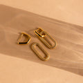Pave Link Hoops: Gold hoops with diamond-accented rectangular loops offer a refined look, shown on a beige background with soft shadows—an elegant jewelry choice.