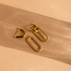 Pave Link Hoops: Gold hoops with diamond-accented rectangular loops offer a refined look, shown on a beige background with soft shadows—an elegant jewelry choice.