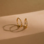 Diamond Link Hoops cast elegant shadows on a beige surface—a modern take on diamond chain link hoops, perfect as bridal or wedding earrings.