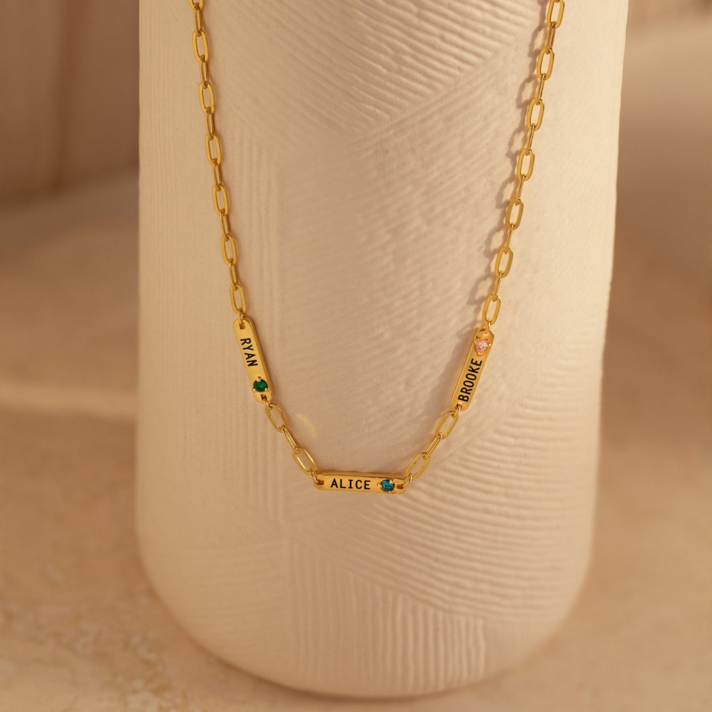 The Mini Name Birthstone Necklace features three gold nameplate charms—EMILY, ALICE, and JORDINE—with delicate flower designs. This personalized necklace makes a unique, thoughtful customized gift.