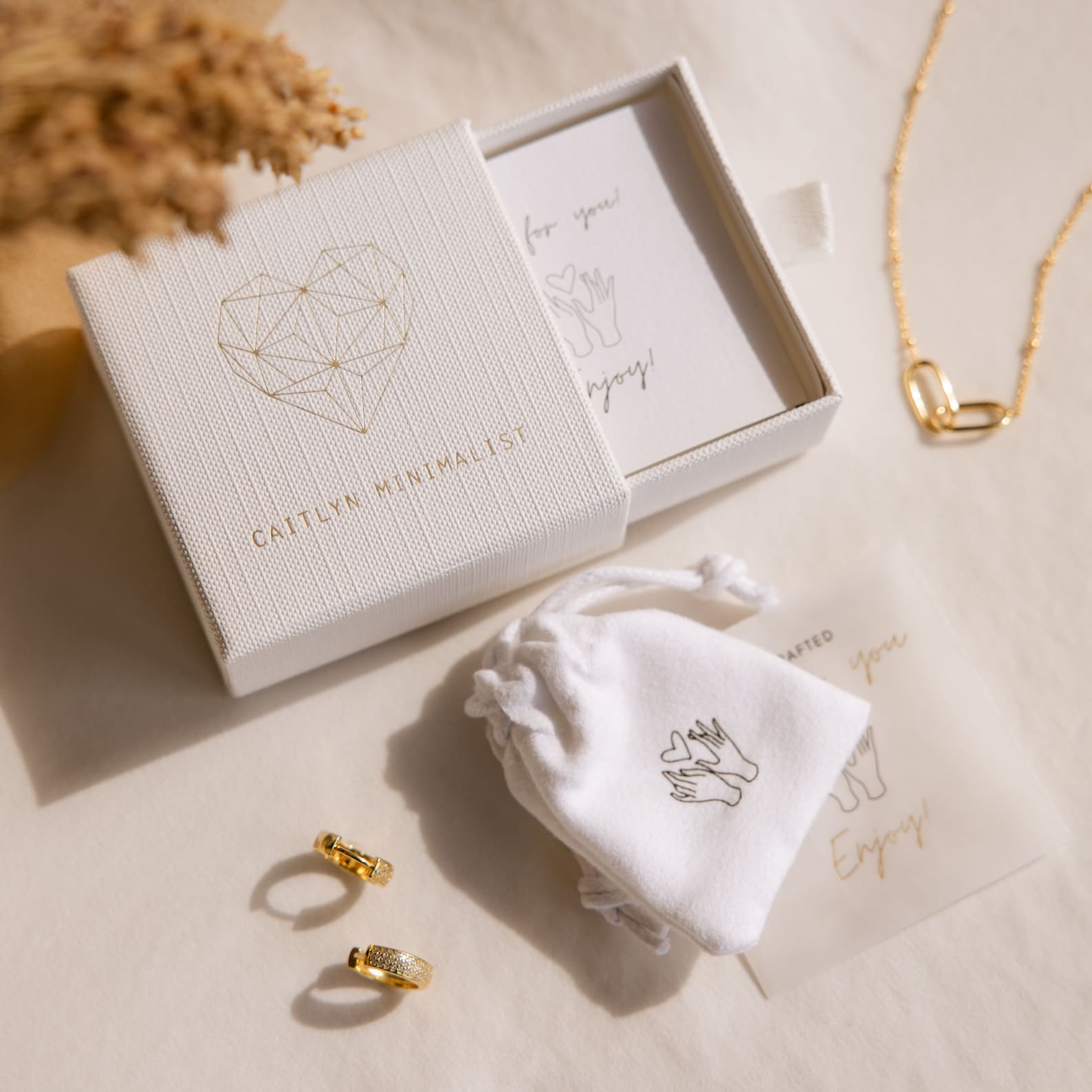 Aquamarine Kite Drop Earrings shown on a beige background, presented in a gift box with a pouch and note, highlighting their minimalist geometric design.
