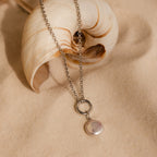 The Round Pearl Charm in Silver is a timeless necklace with a round Mother of Pearl pendant, inspired by the ocean—perfect for adding subtle elegance to any look.