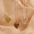 The Fingerprint Heart Necklace, available in gold, rose gold, and silver, rests on textured fabric—making a heartfelt memorial or Mother’s Day gift.