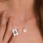 A woman wearing the Fingerprint Coin Necklace, a round silver pendant engraved with a unique fingerprint—an elegant and meaningful Mother’s Day gift.